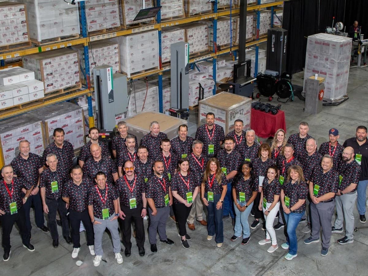 Large team of customers in matching custom all-over print Uncorp Wear polos at a trade show