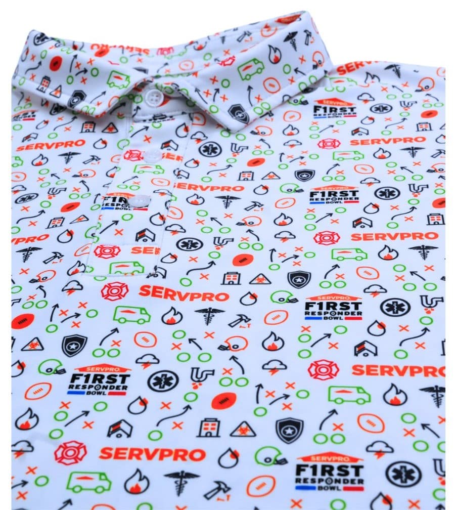 Flat lay of a white polo printed with red, green and black icons on a white background