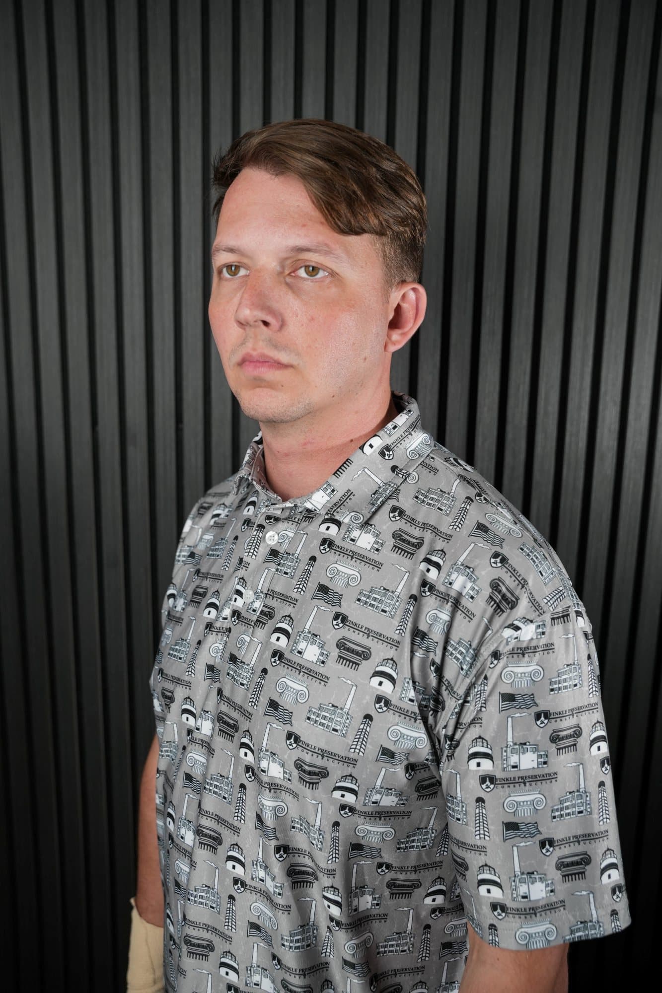 Man in a grey all-over print polo in a studio