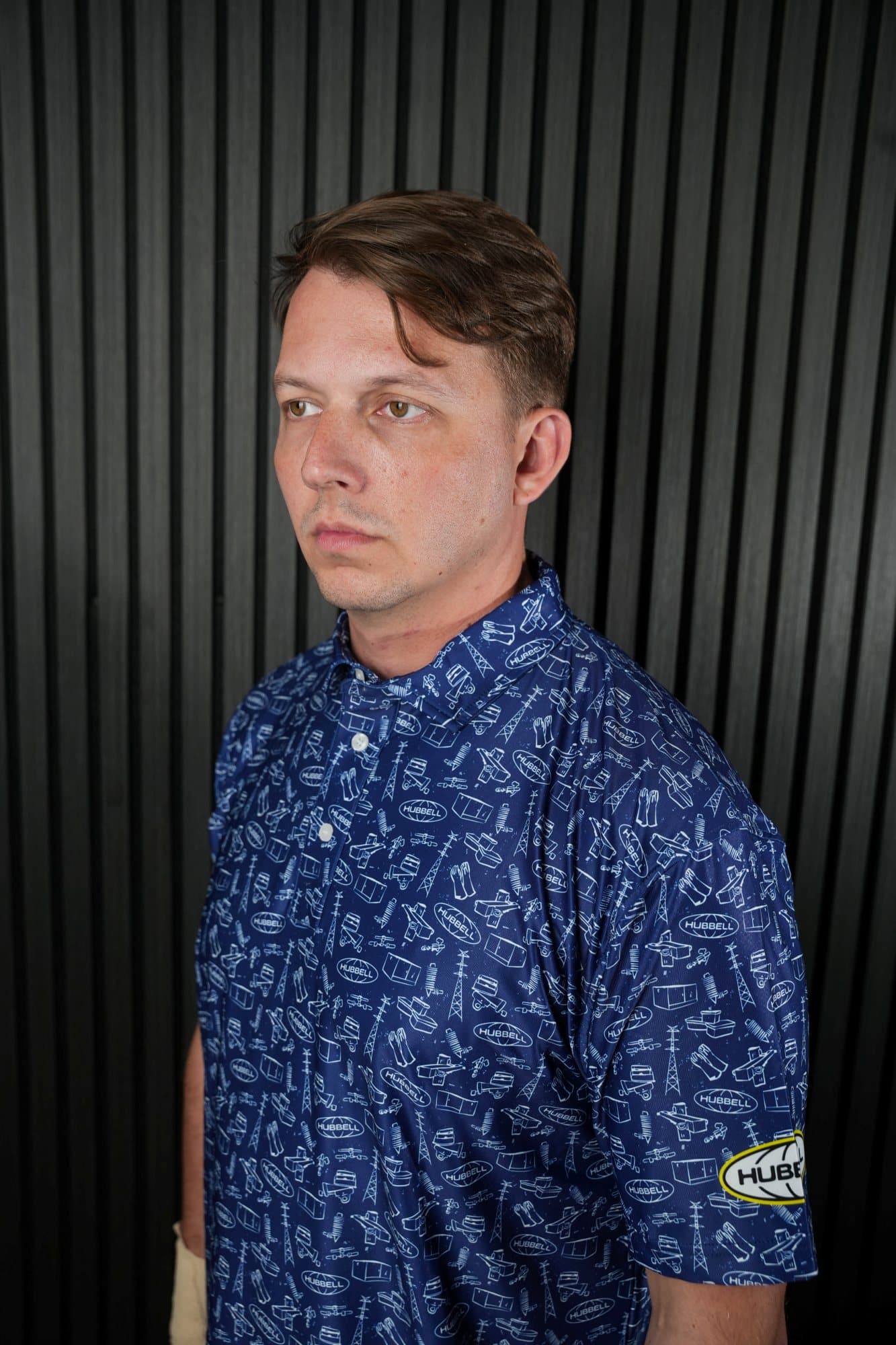 Man in a navy all-over print polo in a studio