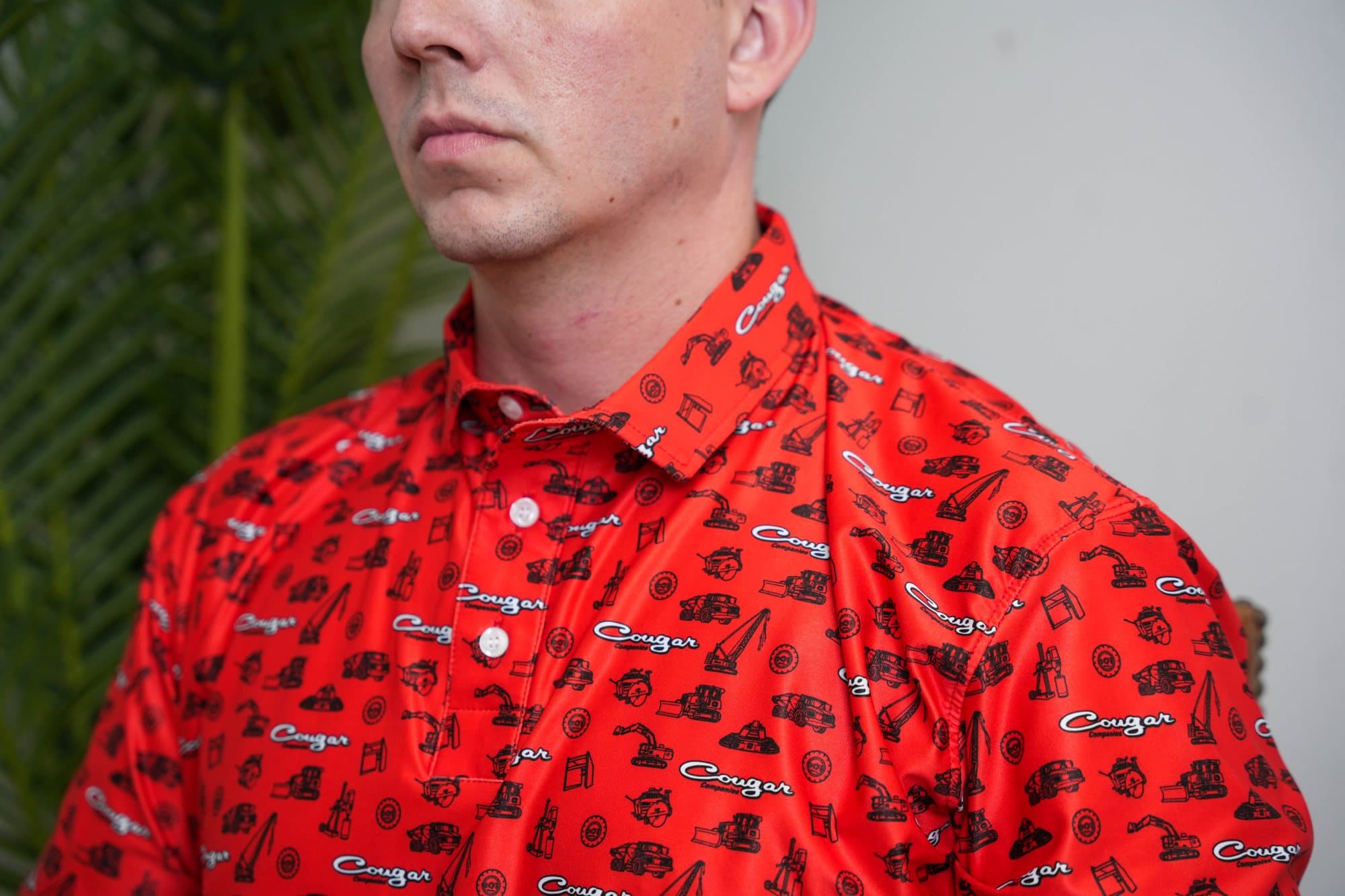 Close-up of a red polo with black truck and equipment icons