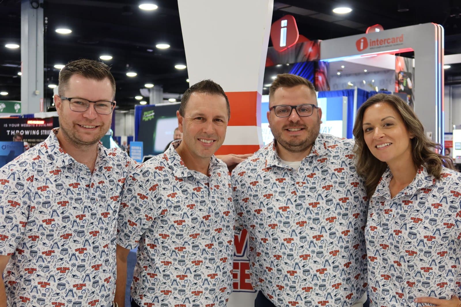 Team of customers in matching custom all-over print Uncorp Wear polos at a trade show
