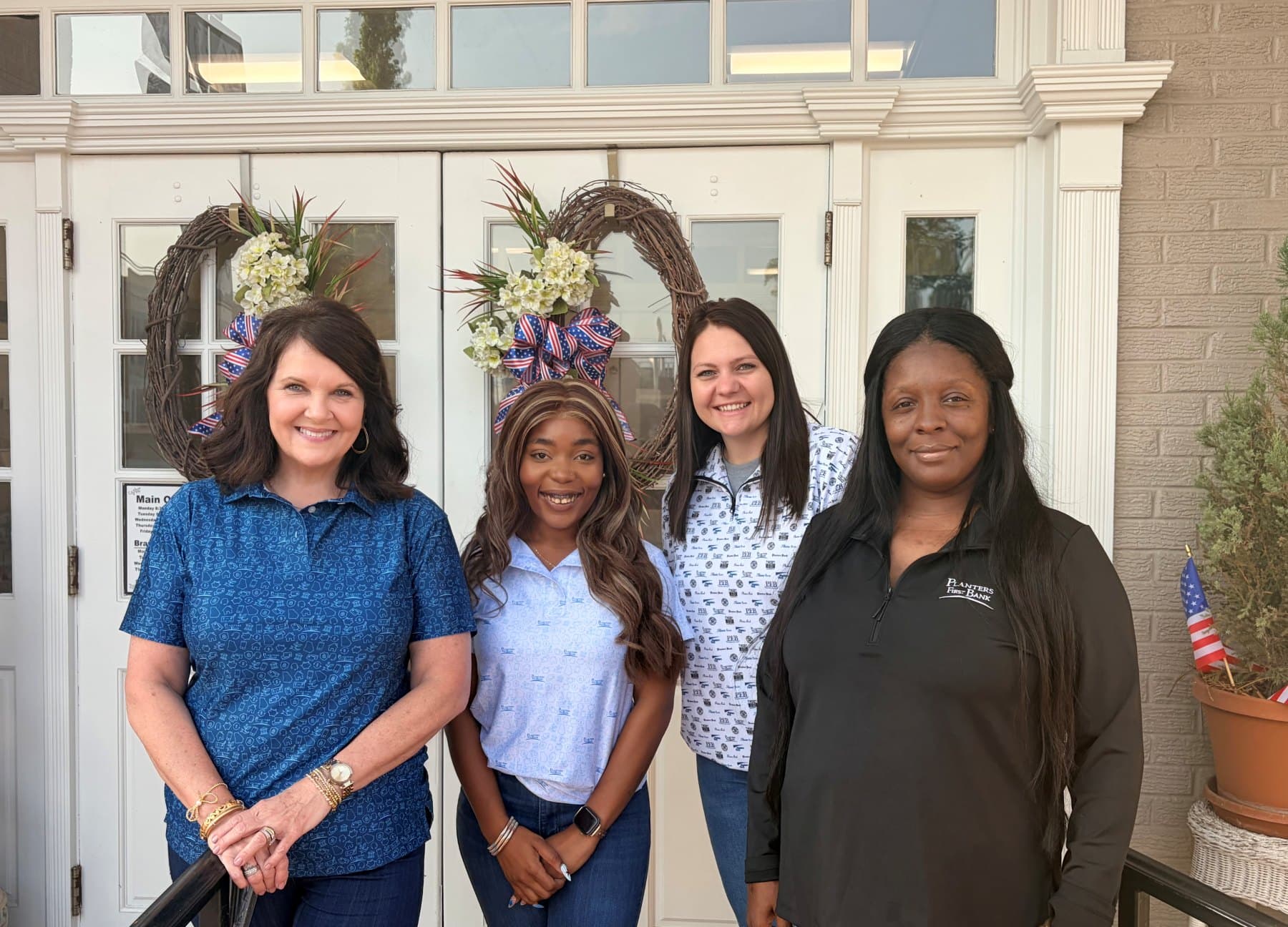 A community bank team gathered together in matching custom polos and quarter-zips